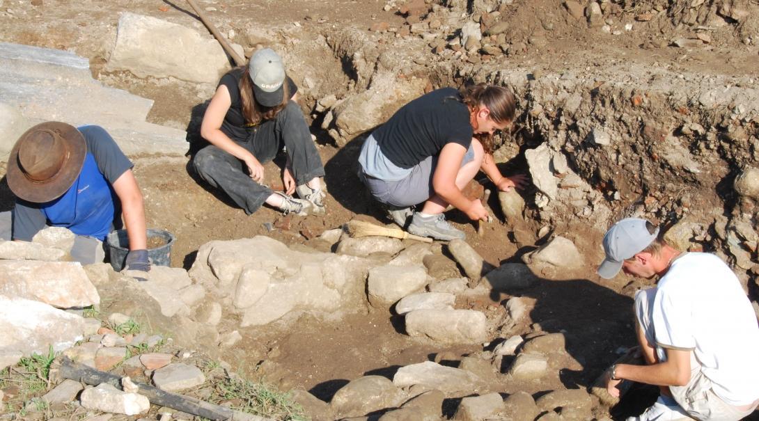 Projects Abroad volunteers on the Archaeology Project in Romania for teenagers help excavate a dig site. Young volunteers assist with site excavation while Archaeology volunteering in Romania for teens.